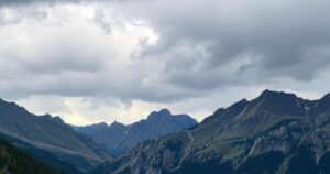 Cloudy skies with showers and a distant storm over mountains, representing weather changes in Montana.