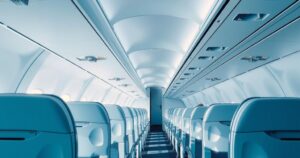 A scene showing an empty airplane interior with seats arranged neatly, symbolizing voluntary deportation flights.