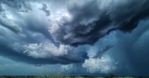 Thunderstorm over a landscape with dark clouds and rain, featuring strong winds and potential hail.